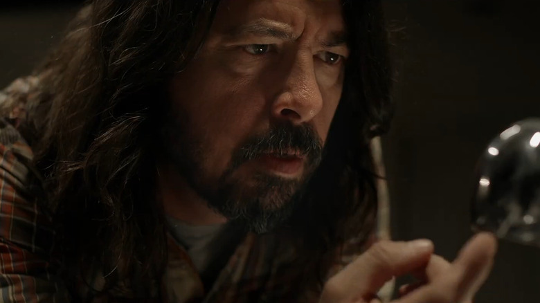 Dave Grohl touching a microphone in concern in Studio 666