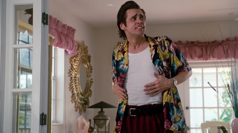 Jim Carrey's Ace Ventura stands in a living room in Ace Ventura Pet Detective.jpg