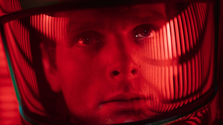 डेव्हिड बोमन 2001 मध्ये अंतराळवीराच्या शिरस्त्राणात आणि लाल दिव्यात: ए स्पेस ओडिसी