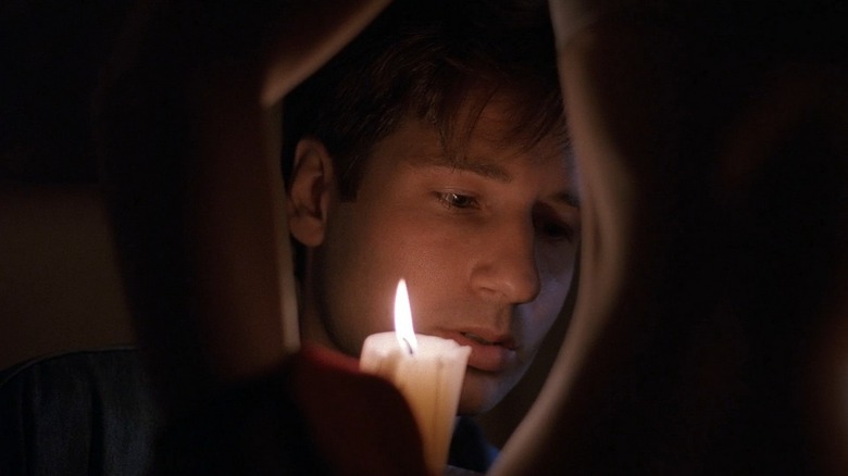 Mulder using a candle to look at Scully's back in The X-Files