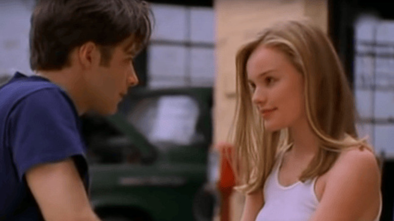 Bella Banks (Kate Bosworth), con una camiseta sin mangas blanca, sonríe tímidamente a William 