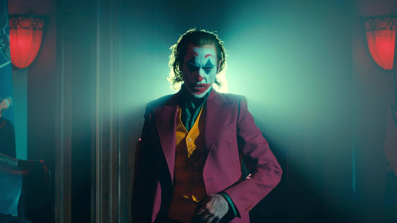 Joaquin Phoenix as Arthur Fleck in his suit with blood on his vest in Joker: Folie a Deux