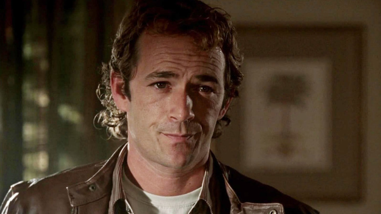 Linc wearing a brown jacket in a darkened room in John from Cincinnati