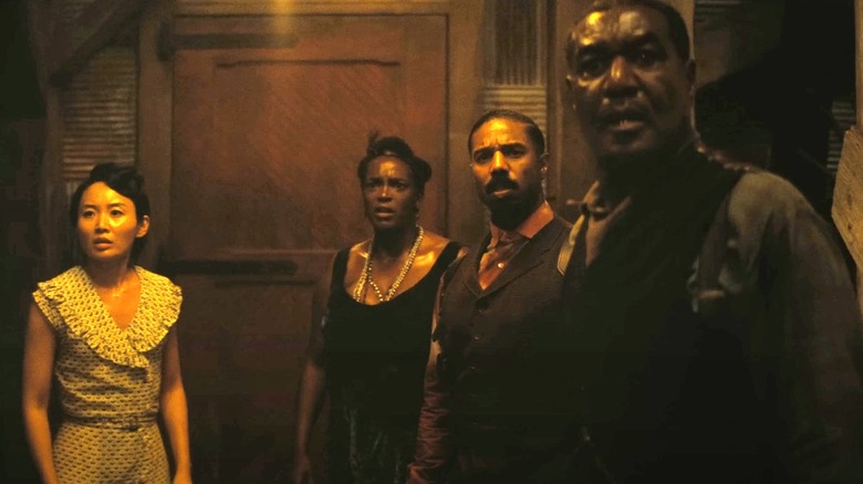 The survivors of the juke joint look out a doorway in Sinners