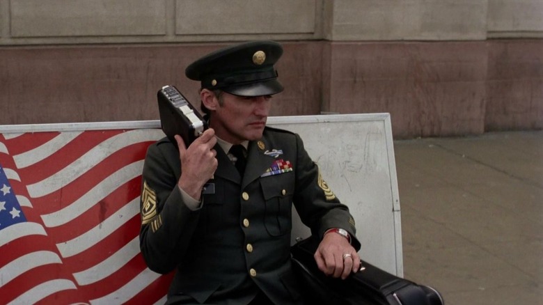 Jack Falen in his military uniform on a bus bench in Tracks