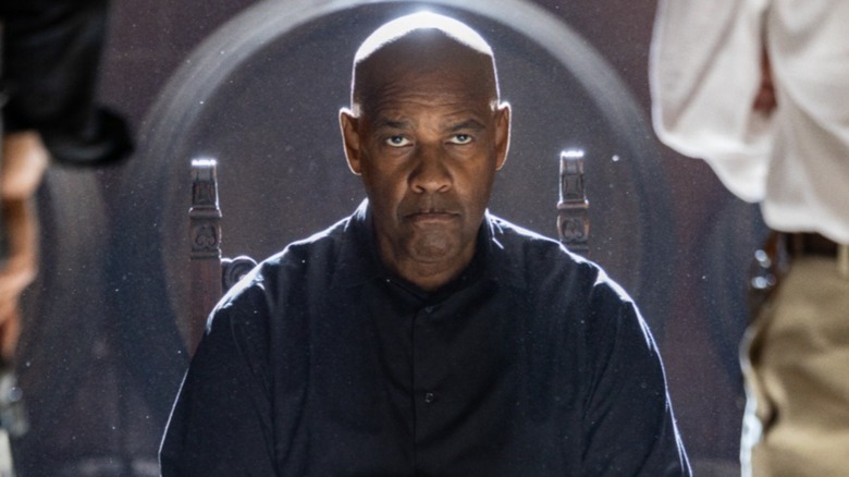 Robert McCall in a big chair with toughs over him in The Equalizer 3