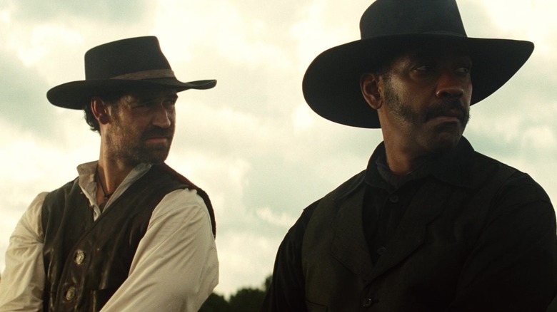 Denzel Washington's Sam Chisholm sits on a horse next to Manuel Garcia-Rulfo's Vasquez in the Magnificent Seven