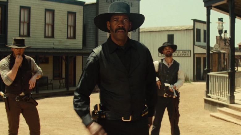 Denzel Washington's Sam Chisholm stands in front of Chris Pratt's Joshua Faraday and Manuel Garcia-Rulfo's Vasquez in The Magnificent Seven