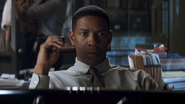 Denzel Washington as Detective John Hobbes sitting at his desk in Fallen