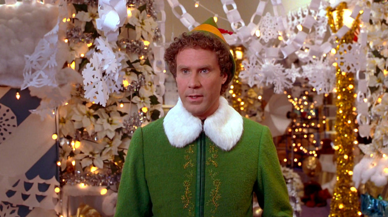 Will Ferrell stands amongst paper snowflakes in Elf