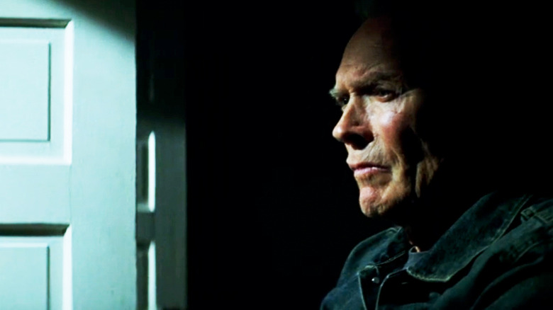 Clint Eastwood's Frankie Dunn stands looking concerned in shadow in Million Dollar Baby
