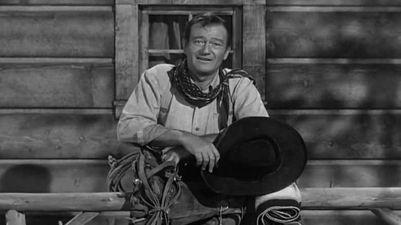John Wayne stands on a porch introducing Gunsmoke