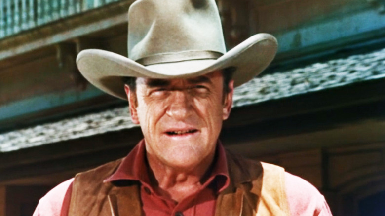 James Arness' Marshal Matt Dillon looks into camera as he stands outside in Gunsmoke
