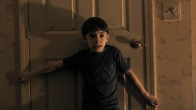 Alex holding a door shut in Weapons