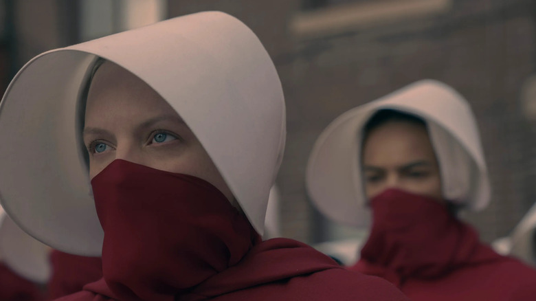 June and other masked Handmaids in their bonnets on The Handmaid's Tale