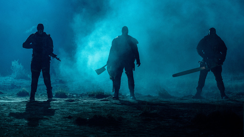 Three super soldiers stand silhouetted in moonlit fog in Onslaught