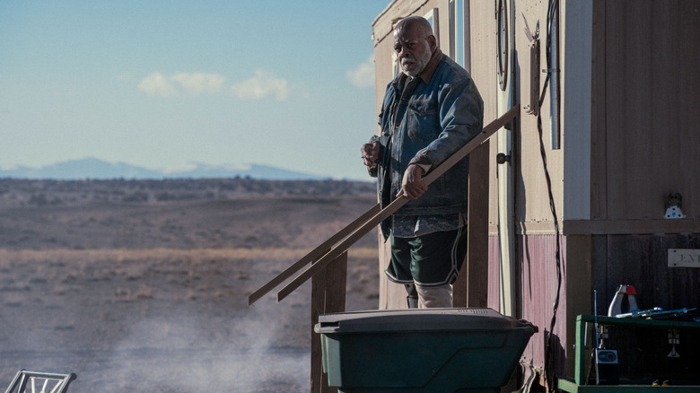 Josiah stands on the short stairway outside his trailer home in Onslaught