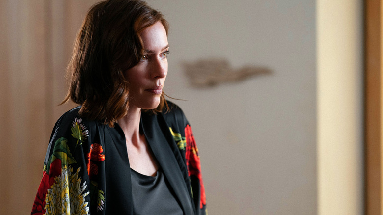 Hanna Kammler wears a robe and smiles at someone off screen in Onslaught