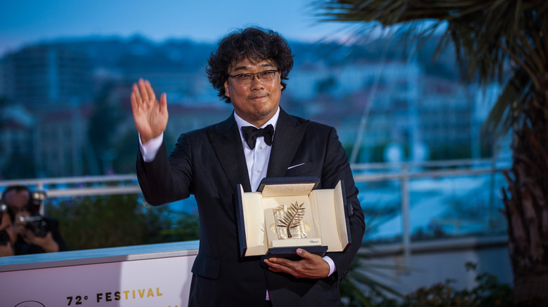 Bong Joon Ho waving while holding an award