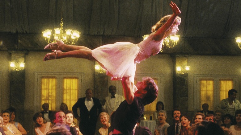 patrick swayze holding up jennifer grey in a room full of people in the movie dirty dancing