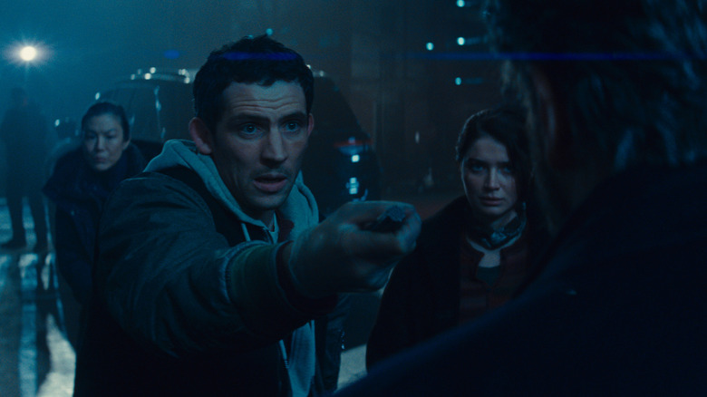 Daniel, holding the alien device, stands with Jane in Disclosure Day