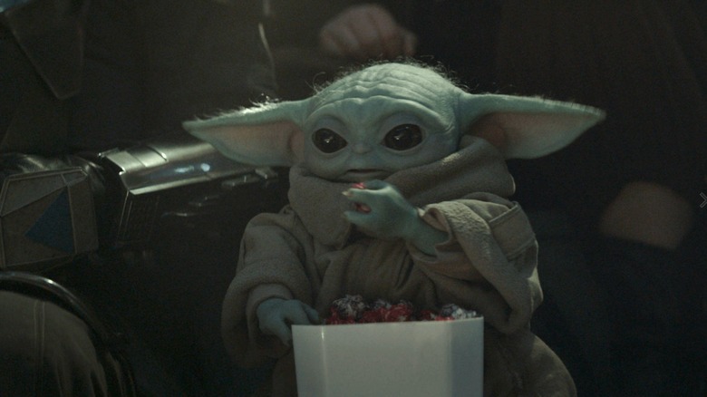Grogu eating a bucket of snacks in The Mandalorian and Grogu