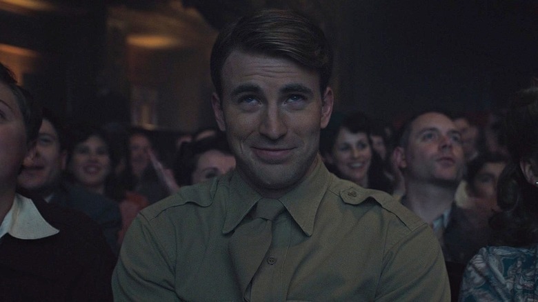 Chris Evans as Steve Rogers sitting in a theater in Captain America: The First Avenger
