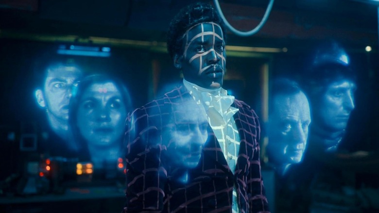 Ncuti Gatwa as the Fifteenth Doctor surrounded by holograms of previous Doctors on Doctor Who