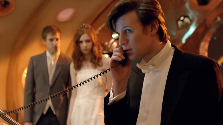 Doctor Who, the 11th doctor receiving a telephone call near Rory and Amy