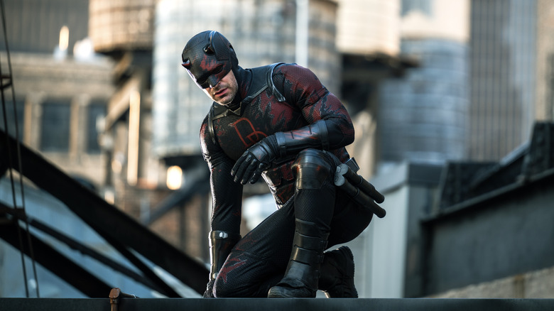 Charlie Cox as Daredevil kneeling on a rooftop in Daredevil: Born Again