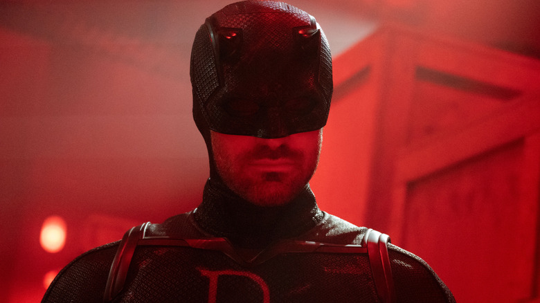 Charlie Cox as Daredevil bathed in red light in a warehouse in Daredevil: Born Again