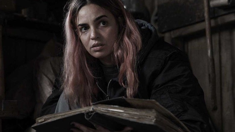 Souheila Yacoub as Alice holding the Book of the Dead in Evil Dead Burn