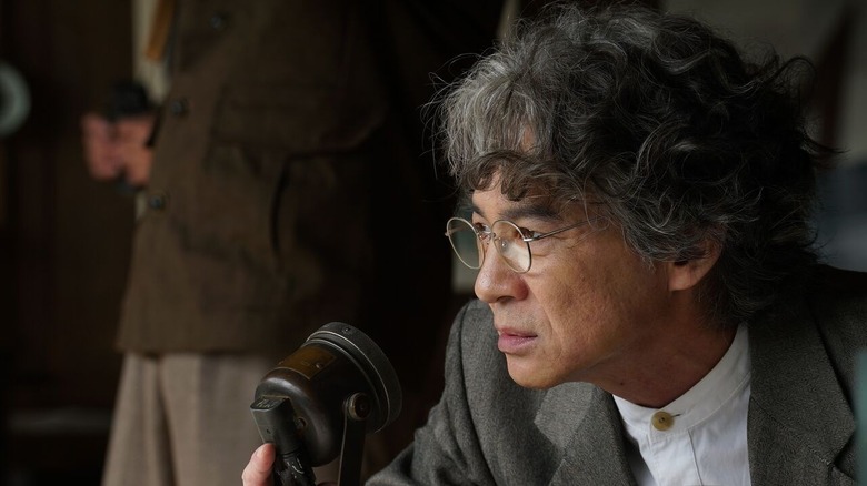 Hidetaka Yoshioka as Kenji Noda in front of a microphone in Godzilla Minus Zero