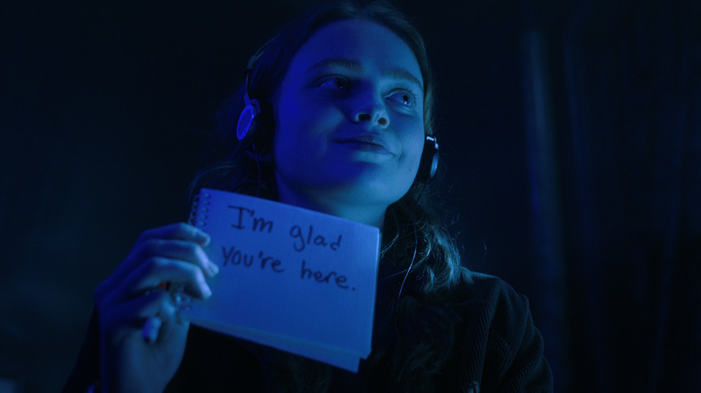 Max smiling while holding up a card that says 