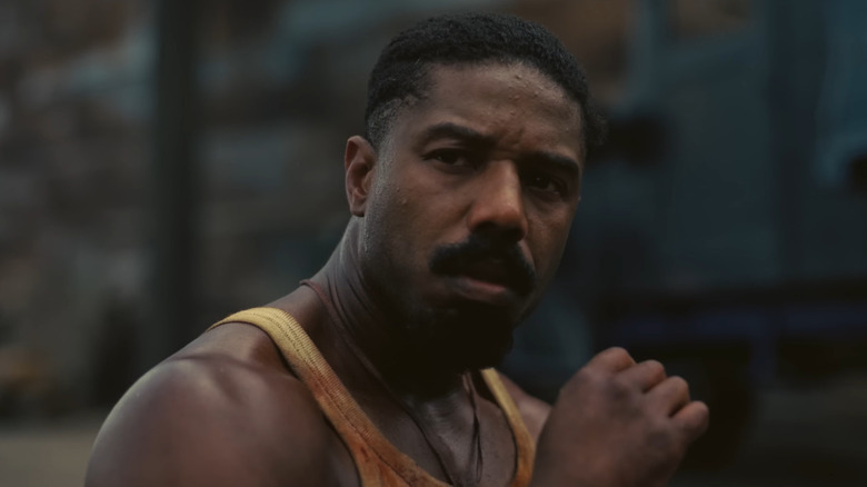 Michael B. Jordan as Smoke sitting outside the club in Sinners