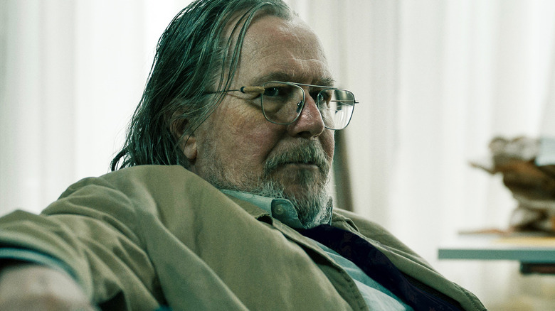 Gary Oldman as Jackson Lamb sits on a couch in his office in Slow Horses