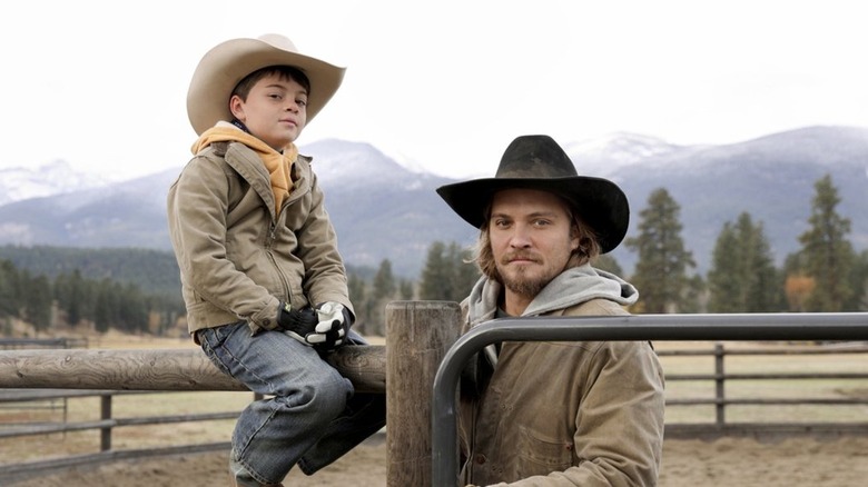 Tate sits on the fence next to Casey Dutton in Yellowstone
