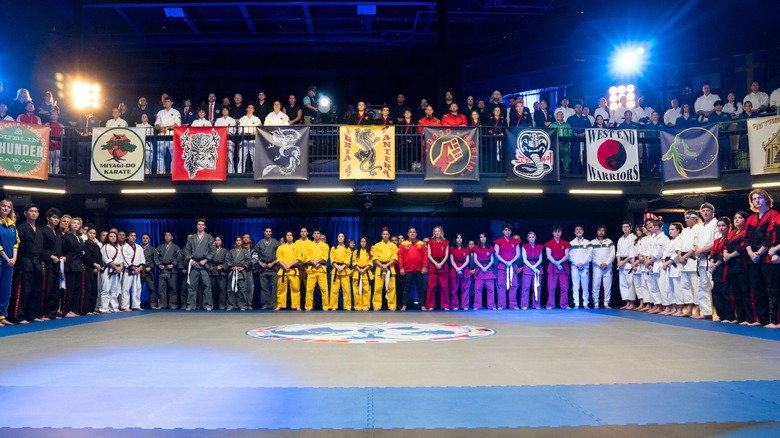 The different teams of the Sekai Taikai standing around the karate mat in Cobra Kai