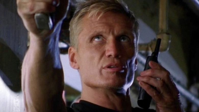Dolph Lundgren pointing a gun and speaking into a walkie talkie as Marko in Chuck