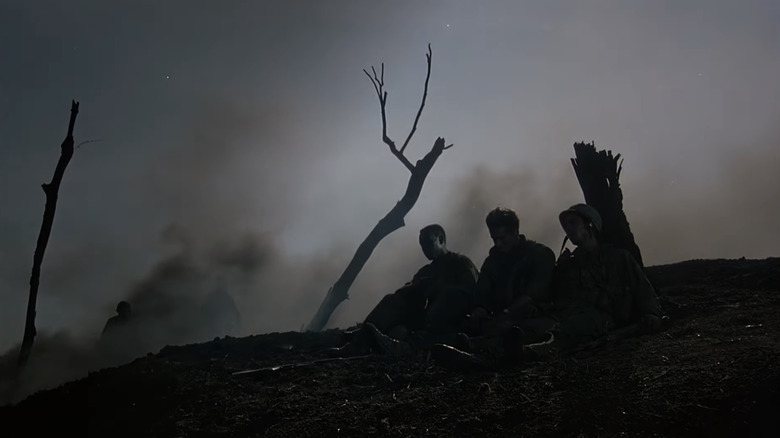 Soldiers sit in a scorched battlefield in Hamburger Hill