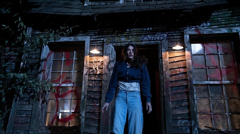 Ella Rubin as Clover looking terrified standing outside a creepy house in Until Dawn