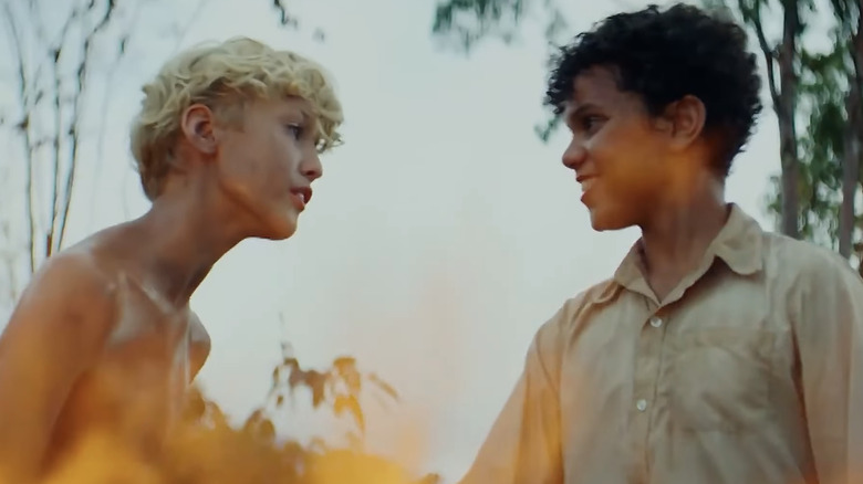 Lox Pratt stars's Jack stands opposite Winston Sawyer's Ralph with a fire visible in the foreground in Lord of the Flies