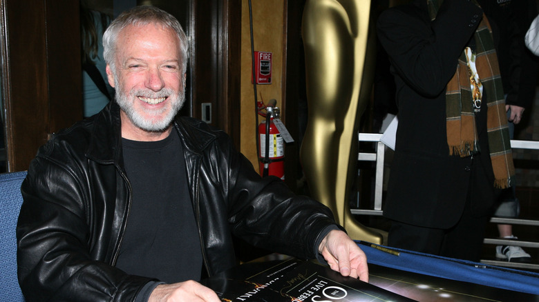 Drew Struzan holds his poster for the 80th Academy Awards