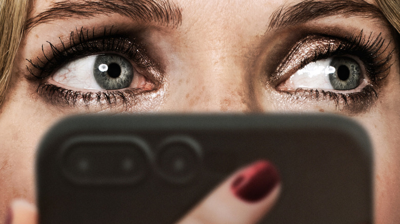 Meghann Fahy's Violet looking at her phone on the poster for Drop