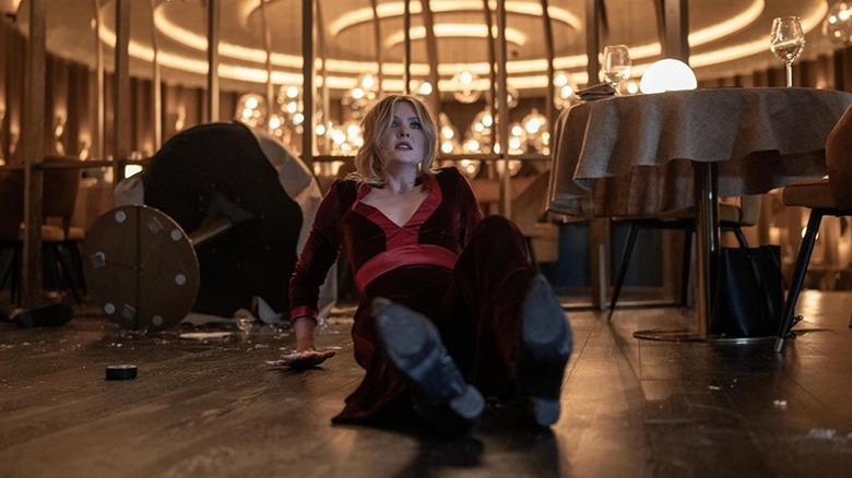 Meghann Fahy's Violet on the ground surrounded by broken glass in Drop