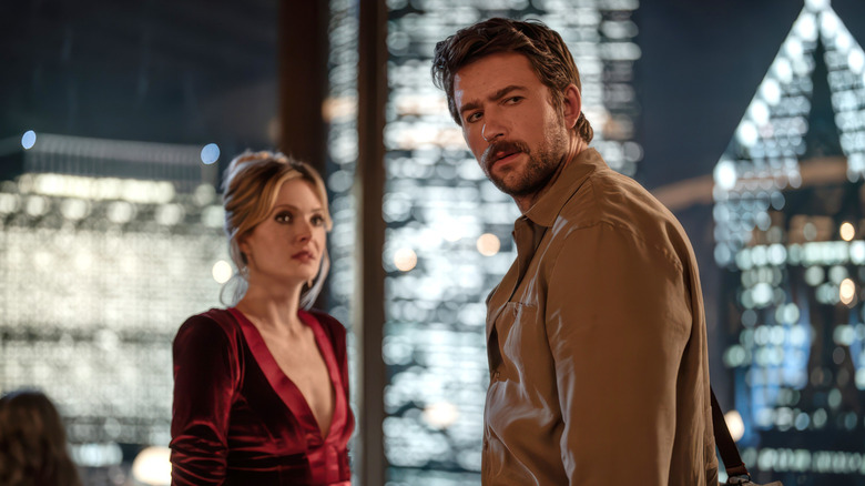 Meghann Fahy's Violet and Brandon Sklenar's Henry standing in the restaruant in Drop
