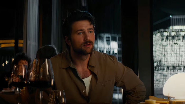 Henry sitting at a table in a restaurant in the movie Drop.