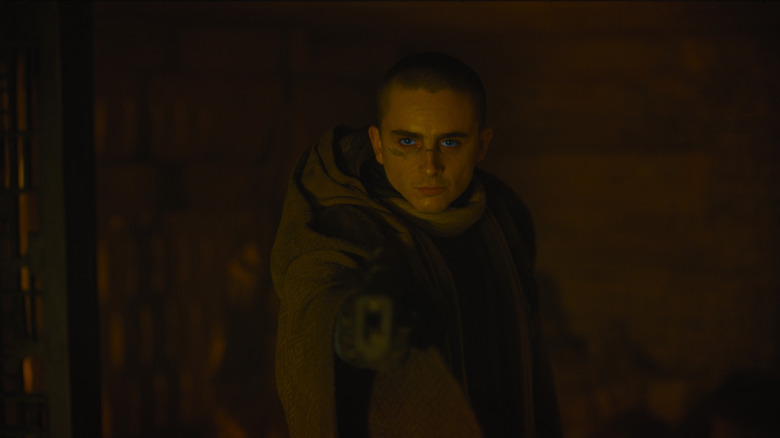 Timothée Chalamet as Paul Atreides with a shaved head and wearing desert gear in a cave in Dune: Part Three
