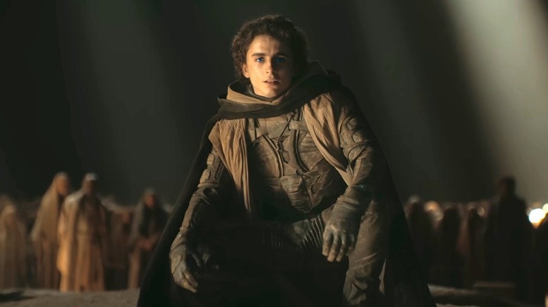 Timothée Chalamet as Paul Atreides kneels in front of his followers in Dune: Part II