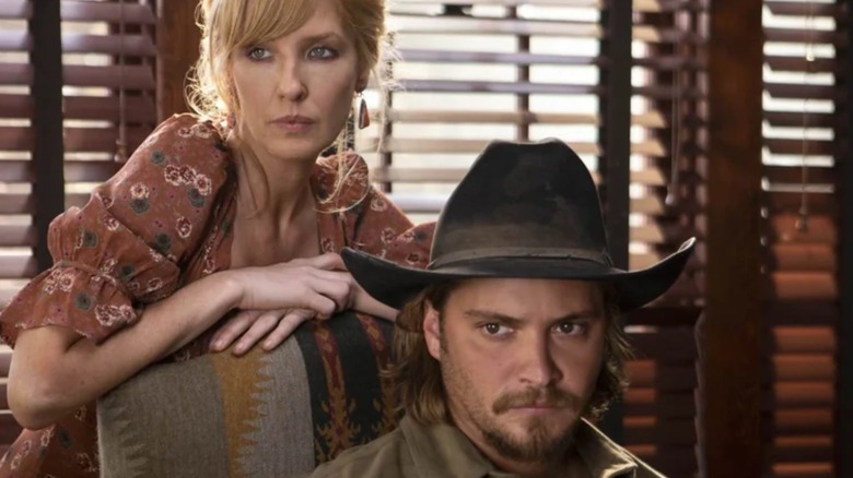 Kayce Dutton sitting in a chair with Beth Dutton leaning behind him